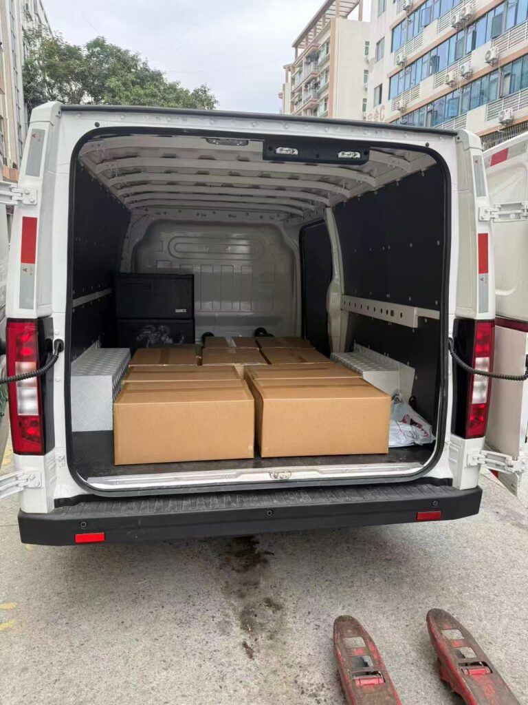 Loading finished garment orders into a logistics van for international shipping from Tetramade Shenzhen.