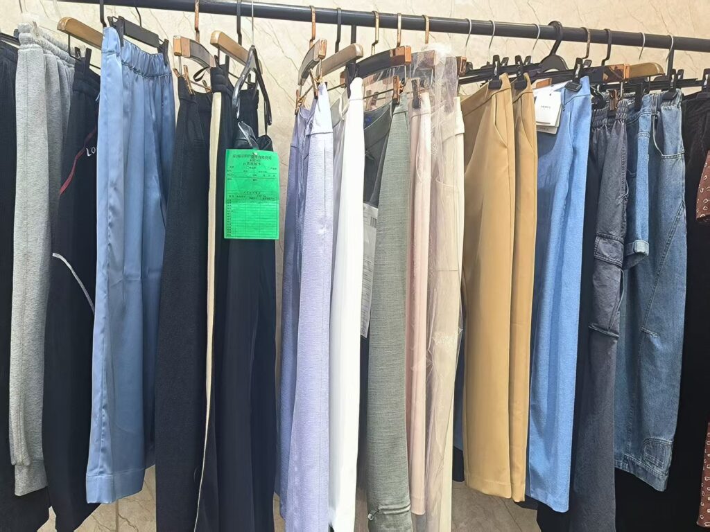Assorted casual tops, T-shirts, and hoodies at Tetramade's sampling center, featuring enzyme wash and pigment dyeing.
