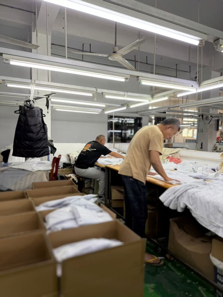 Professional garment pressing and quality inspection for white woven shirts at Tetramade workshop.