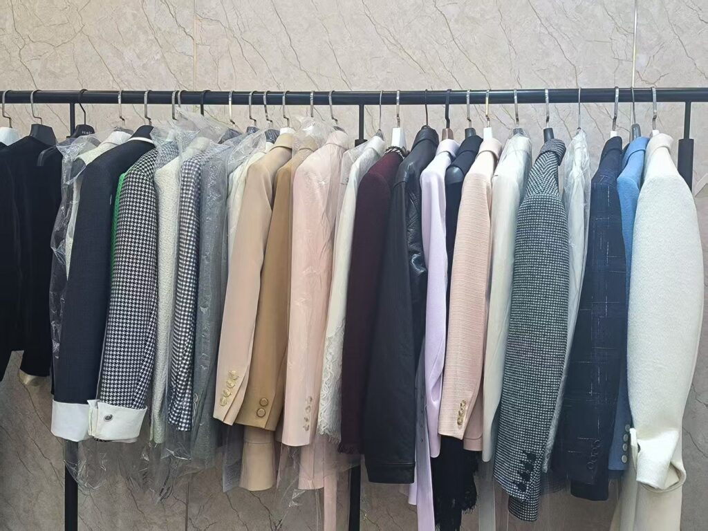 A collection of tailored blazers and structured outerwear at Tetramade's facility, demonstrating high-end garment finishing.